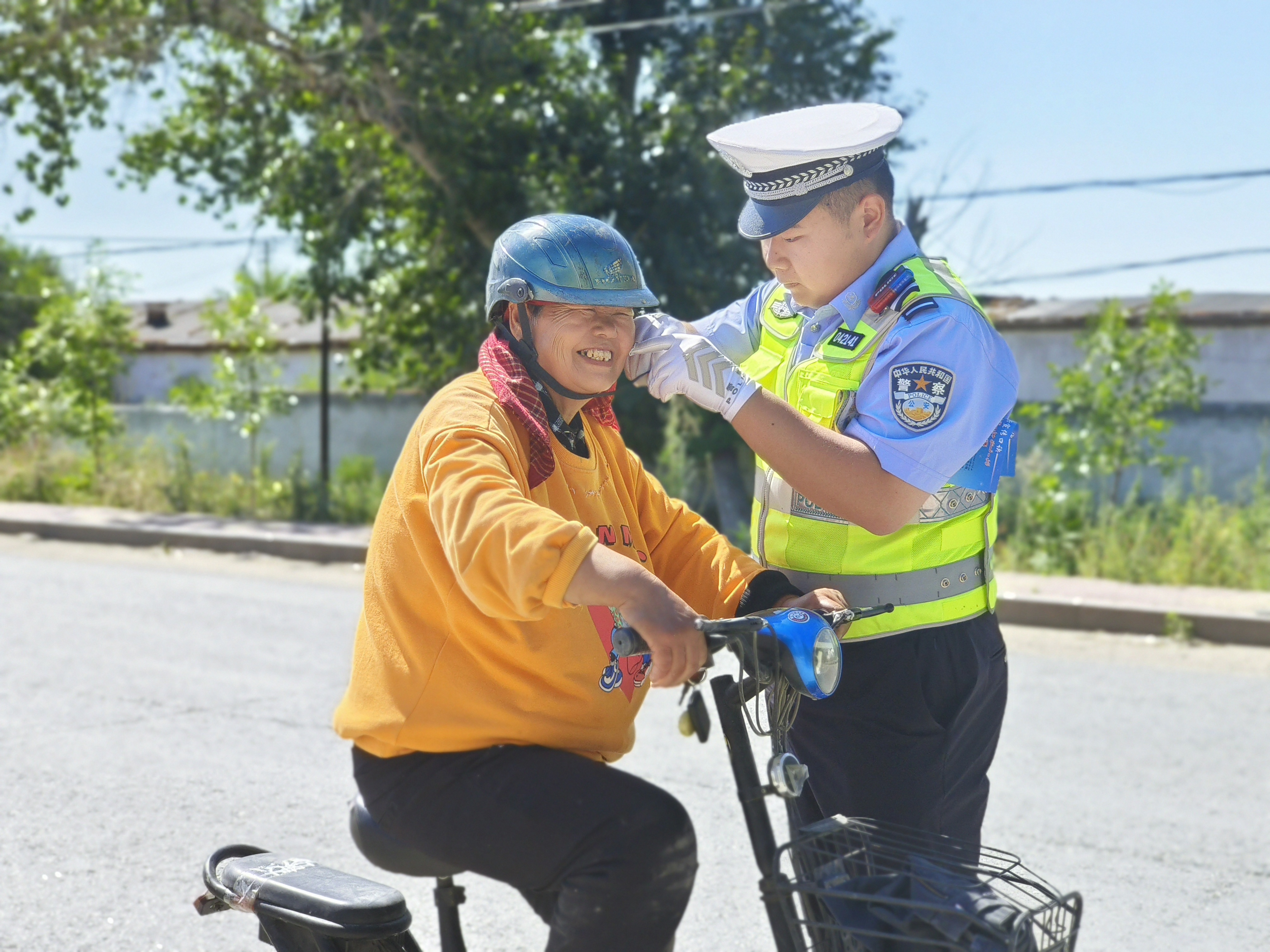 民警为街面为佩戴头盔人员佩戴安全头盔.jpg