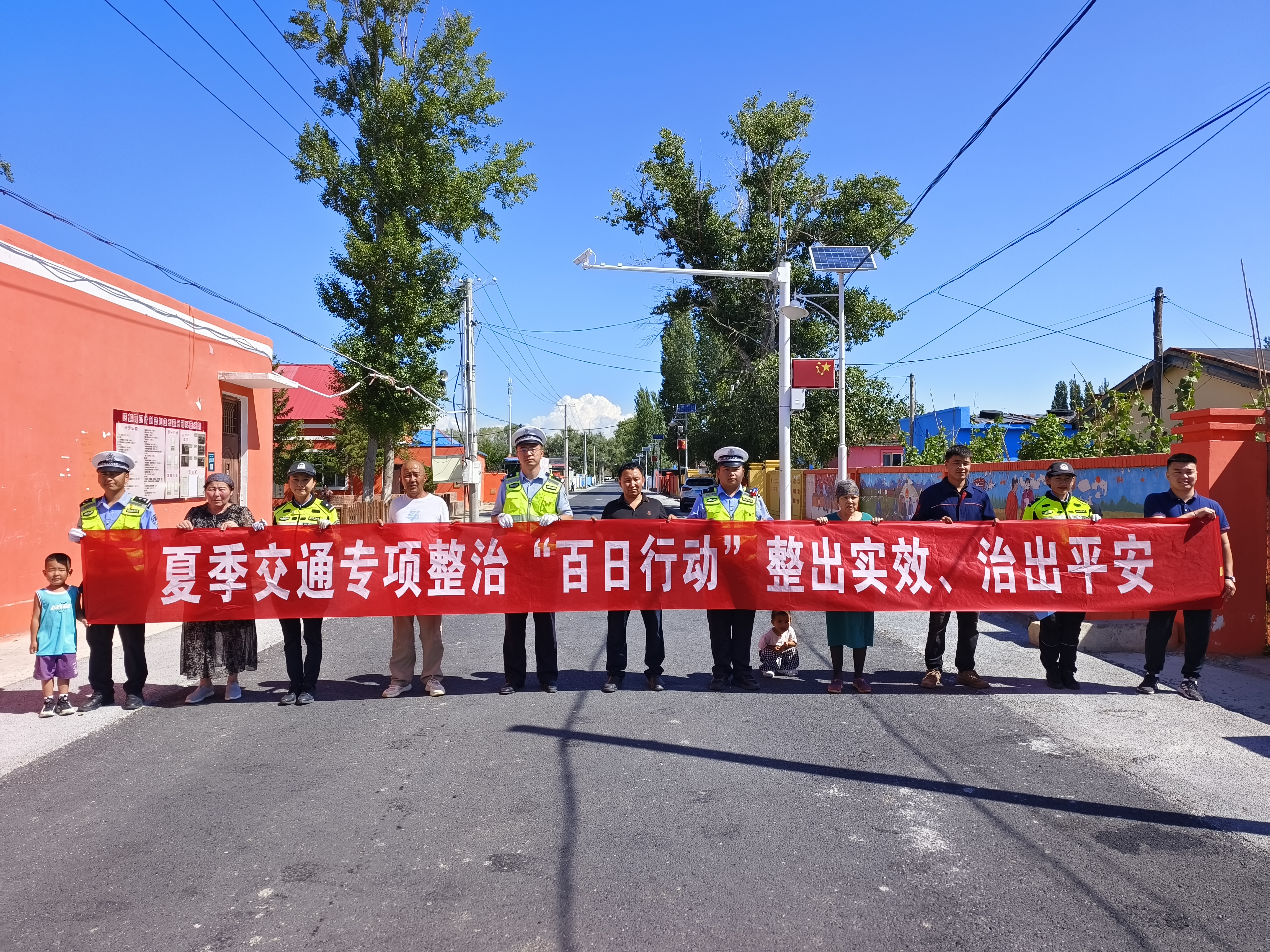 民警与群众一同拉夏季交通百日政治横幅扩大宣传覆盖面.jpg