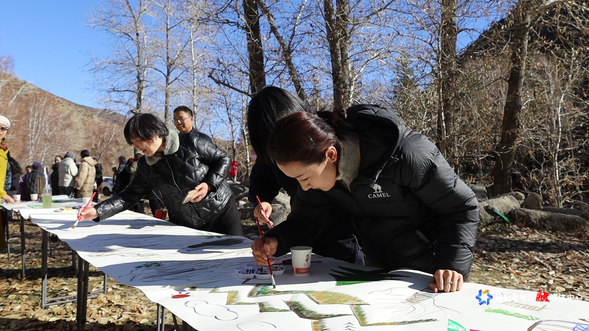 活动现场的创作区域,参与者们围绕着长桌,投入地进行主题绘画创作。
